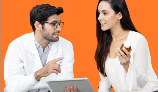 An image of a woman holding a tablet in her hand, discussing something with a man, both standing in front of an orange background.