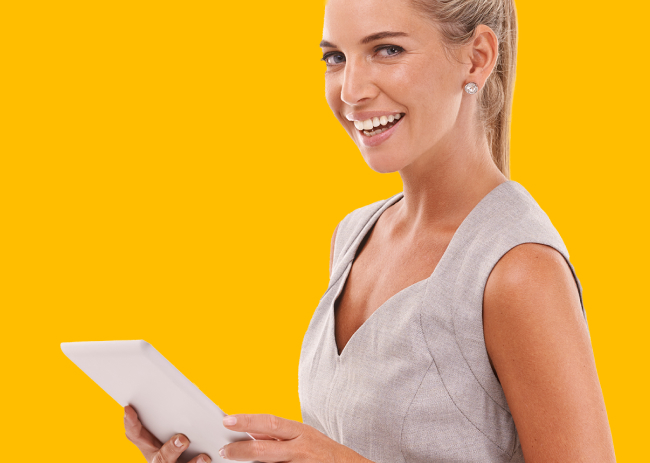 An image of a woman smiling and standing in front of a yellow background.