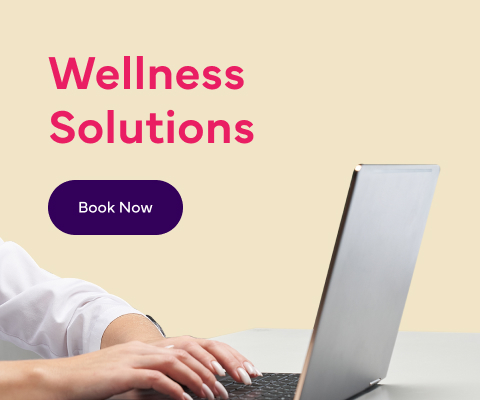 An image of a person working on a laptop with text reading: 'Wellness Solutions ' and a 'Book Now' button.